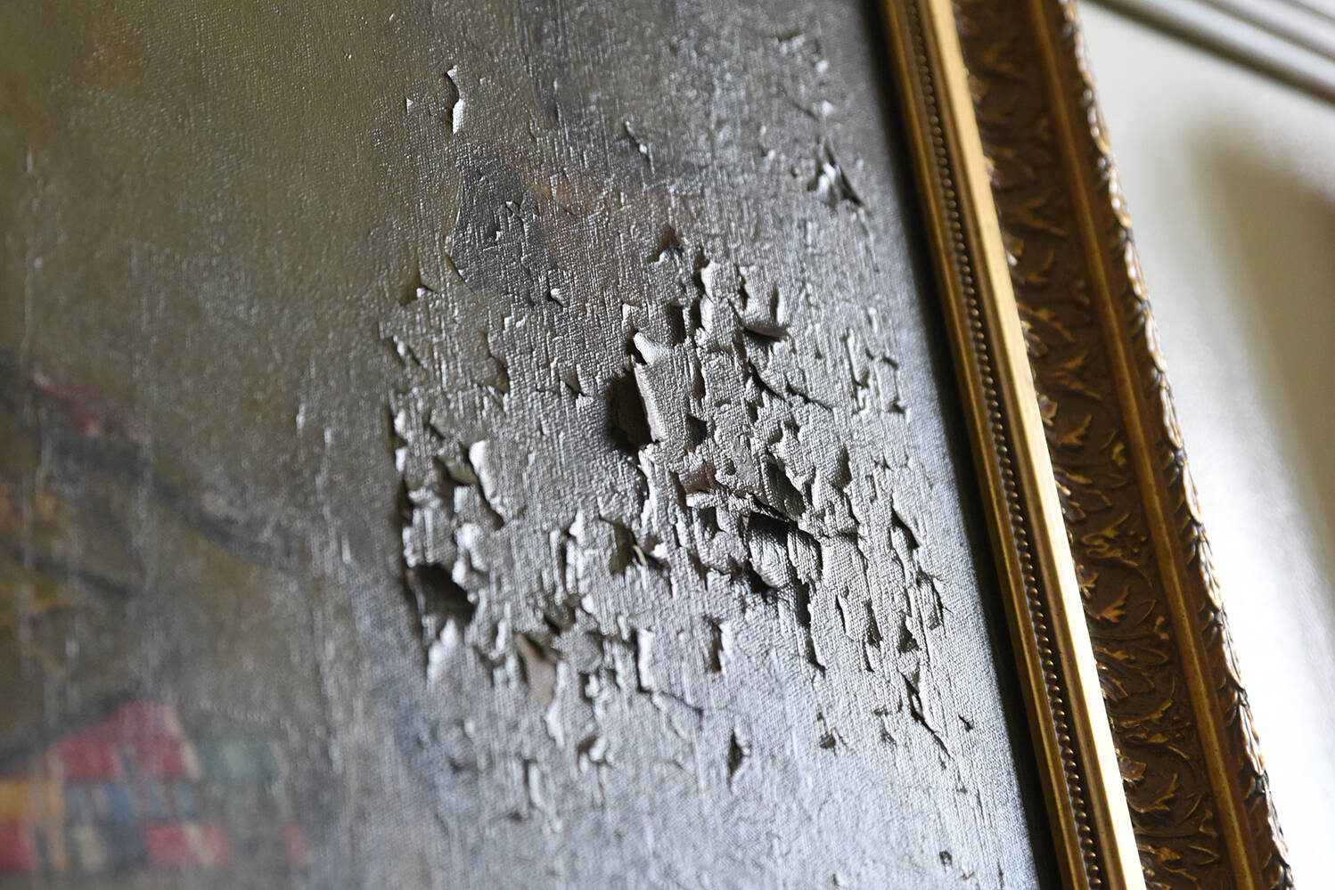 A painting with paint flaking off the canvas.
